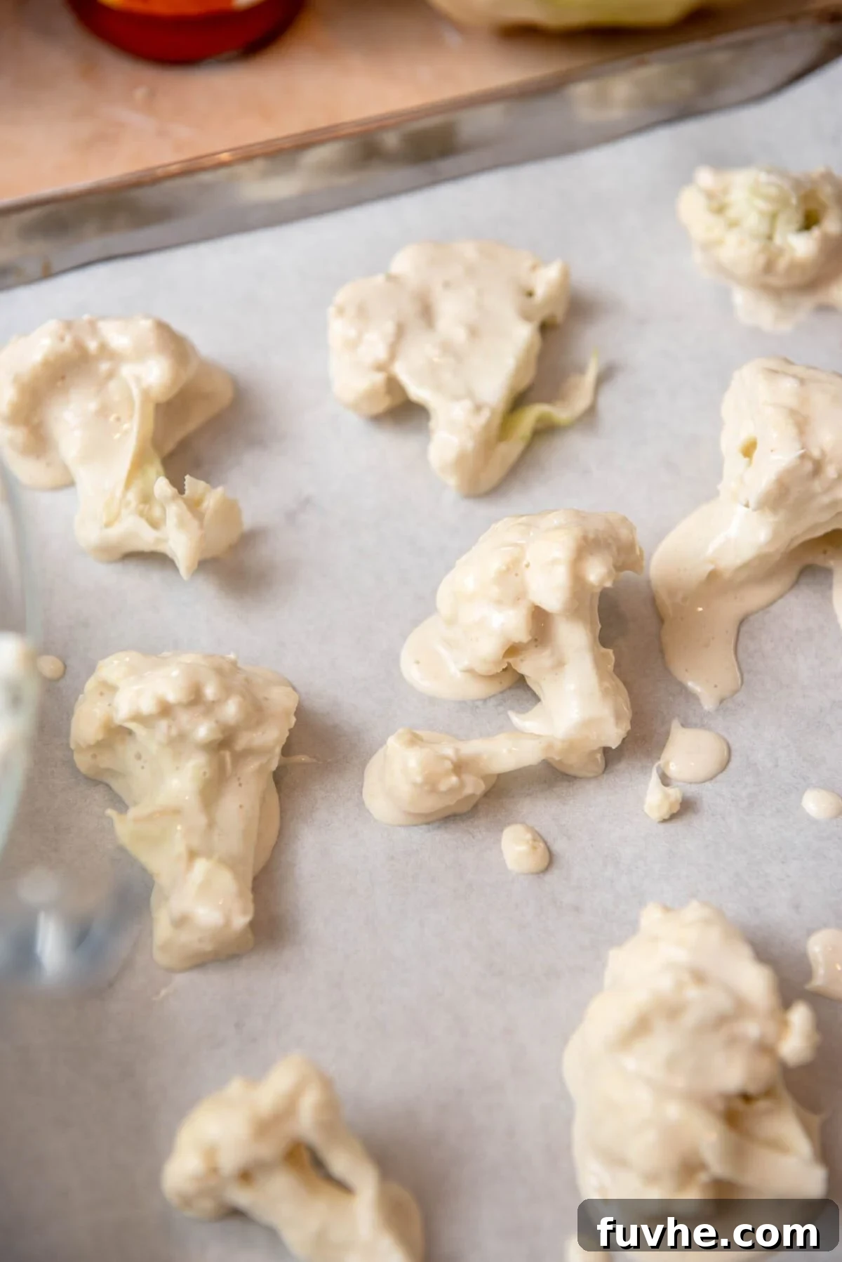 Crispy Buffalo Cauliflower Tacos 5 Cauliflower florets uniformly coated in batter and spaced on a baking sheet.