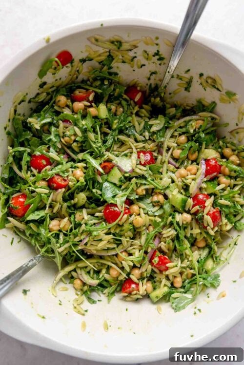 Bright Pesto Orzo Salad 6 Orzo pesto salad with tomatoes and chickpeas in a large mixing bowl.