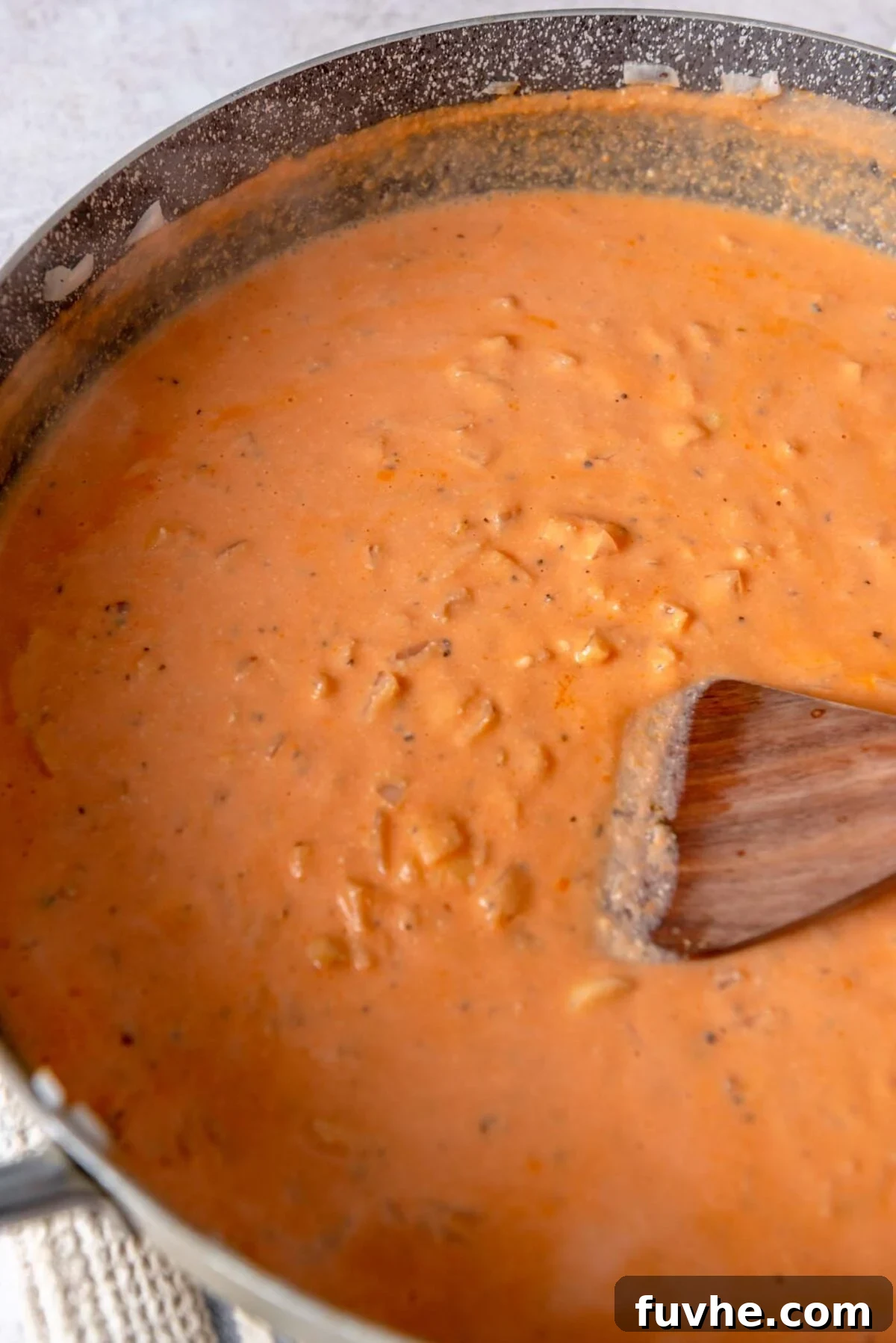 Creamy tomato sauce cooking in a large skillet.