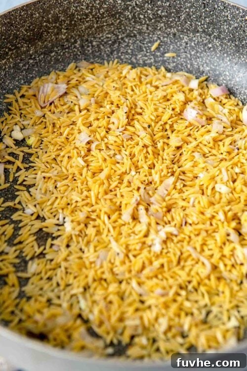 Dry orzo cooking in a pan.