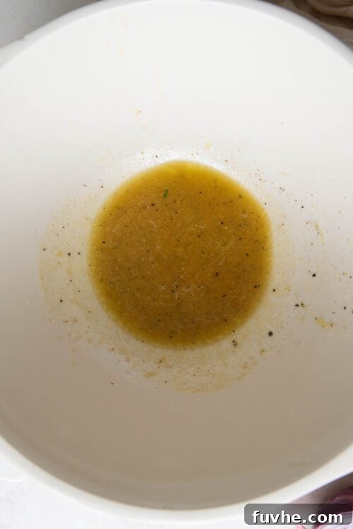 Lime vinaigrette ingredients whisked together in a large mixing bowl.