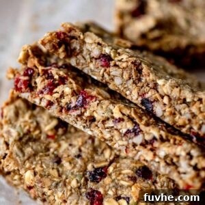 Wholesome Cranberry Granola Bars 9 A close-up view of three freshly baked cranberry granola bars, highlighting their wholesome texture and appetizing golden hue, ready for enjoyment.