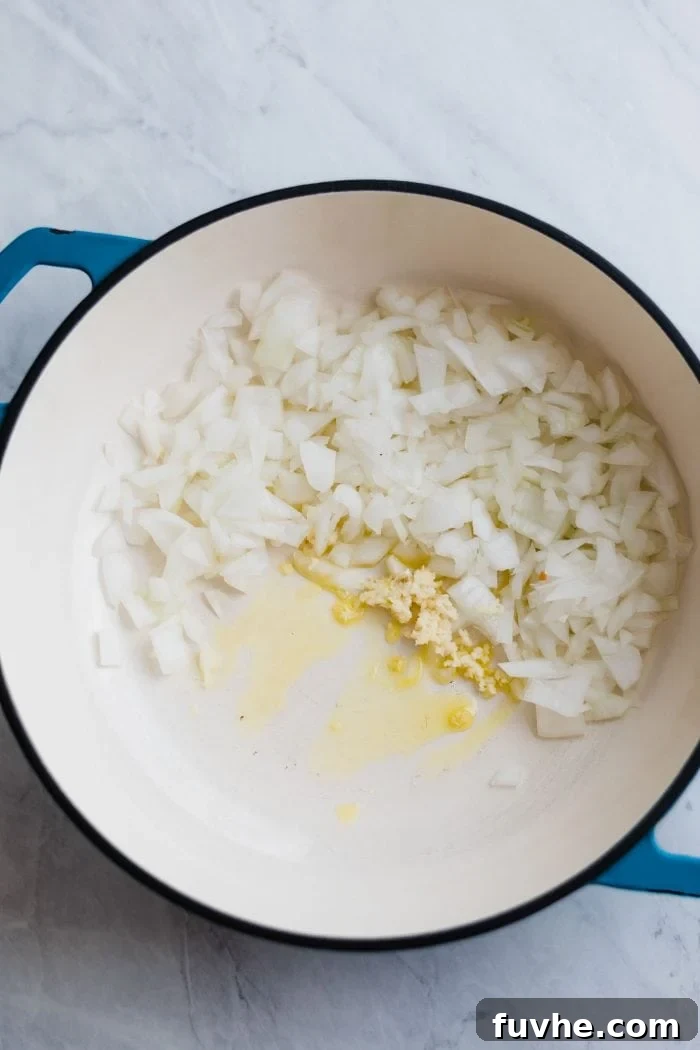 Diced onions, minced garlic, and fresh ginger sautéing in a stock pot with olive oil.