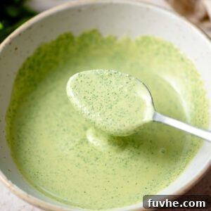 Spoon in a bowl of creamy cilantro tahini sauce.