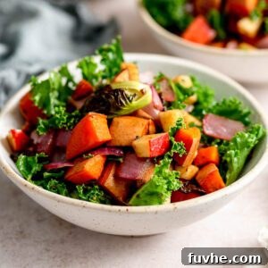 Roasted vegetable kale apple salad with sweet potato in a small bowl.