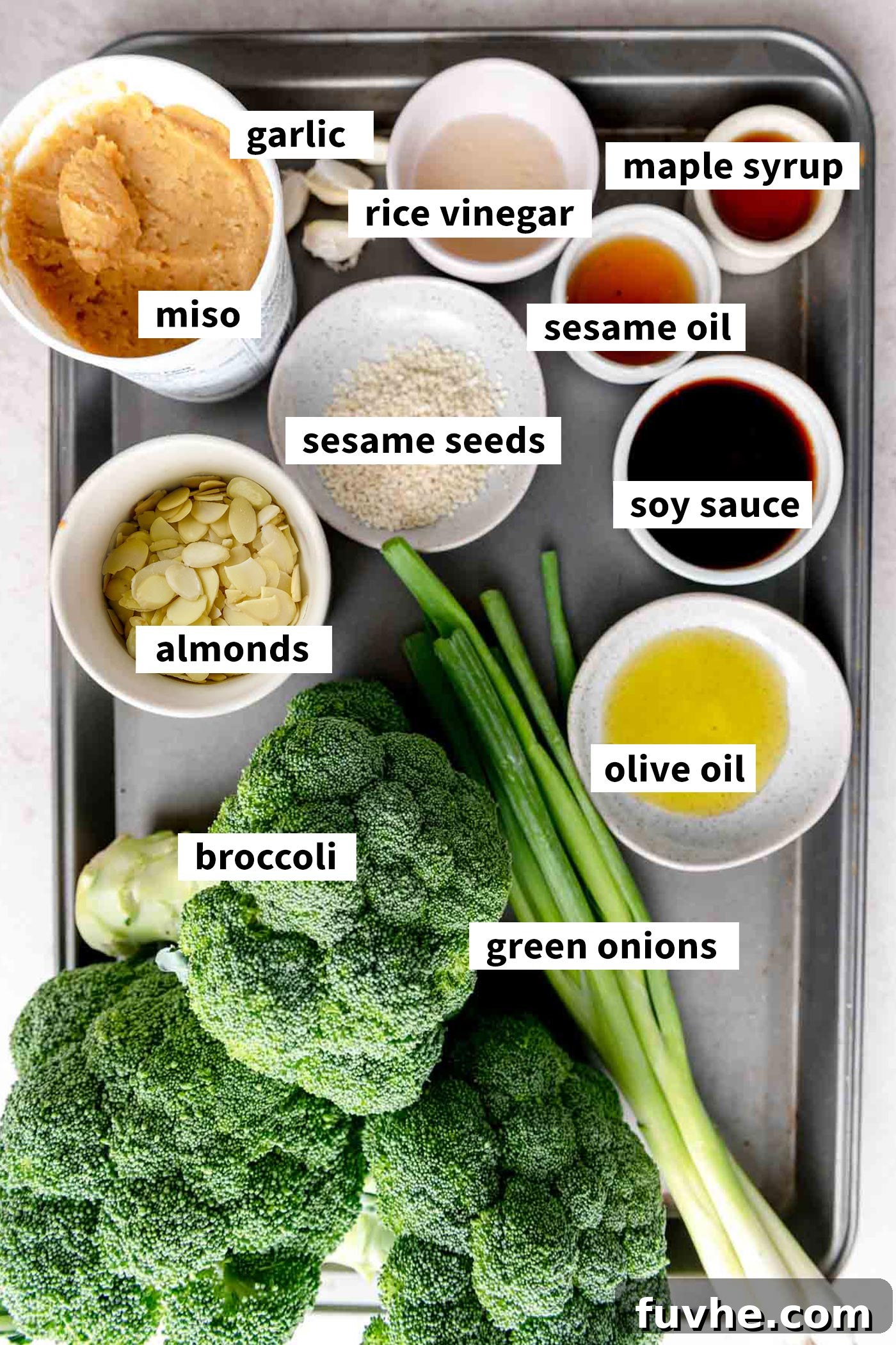 Ingredients for a miso roasted broccoli salad with almonds, sesame seeds and green onions.
