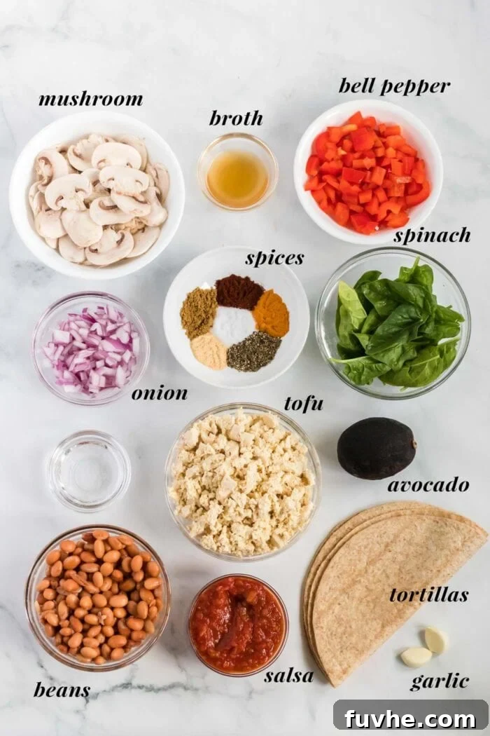A flat lay photograph showcasing all the fresh and colorful ingredients required to make vegan tofu scramble breakfast burritos. Included are blocks of firm tofu, sliced mushrooms, chopped red bell pepper, red onion, garlic cloves, a variety of vibrant spices in small bowls, fresh cilantro, black beans, ripe avocado, and a stack of soft flour tortillas.