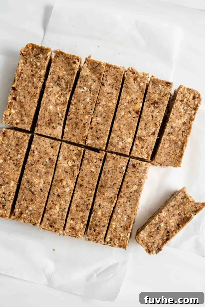 Tropical Coconut Fuel Bars 7 Freshly sliced vegan no-bake almond coconut protein bars, arranged on parchment paper, showcasing their dense and chewy texture.
