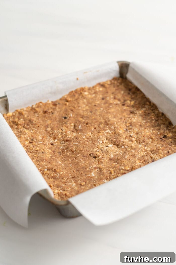 Parchment paper-lined square baking pan of energy bars.