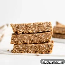 Stack of 3 energy bars sitting on a folded piece of parchment paper. More bars in background.