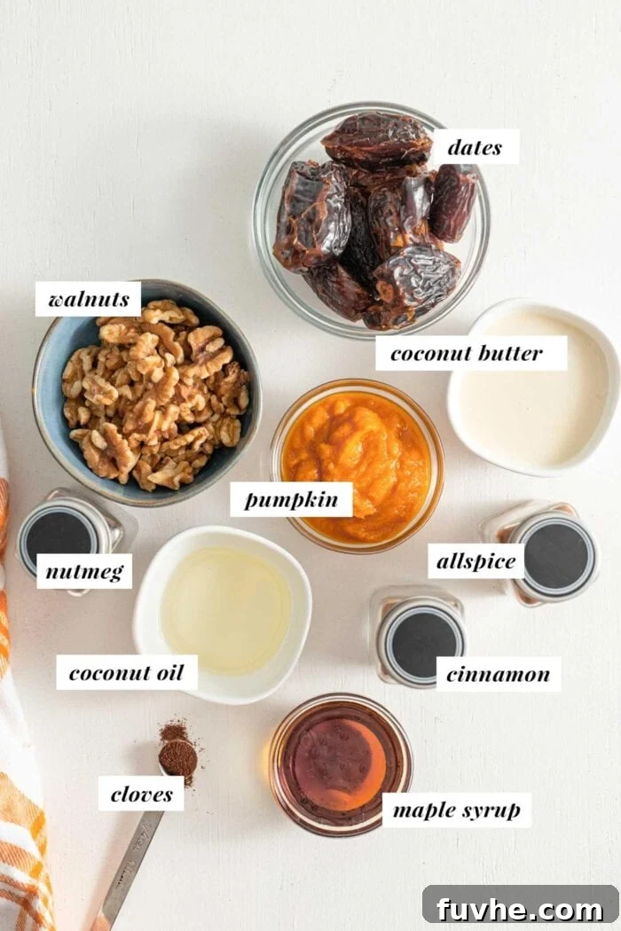 A carefully arranged display of ingredients including walnuts, dates, coconut oil, coconut butter, pumpkin puree, and maple syrup, ready for making no-bake vegan pumpkin pie tarts.