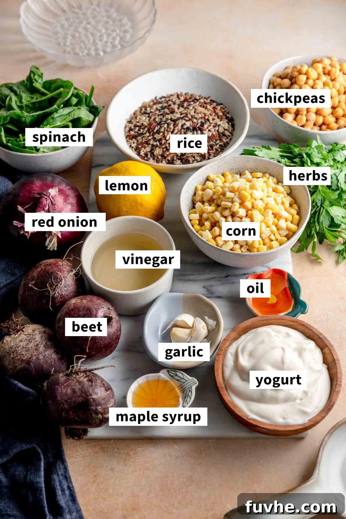 All the fresh ingredients meticulously gathered in various small bowls, neatly arranged on a rustic wooden cutting board, ready for assembling a vibrant wild rice bowl featuring chickpeas, corn, a creamy yogurt dressing, and crisp spinach leaves.