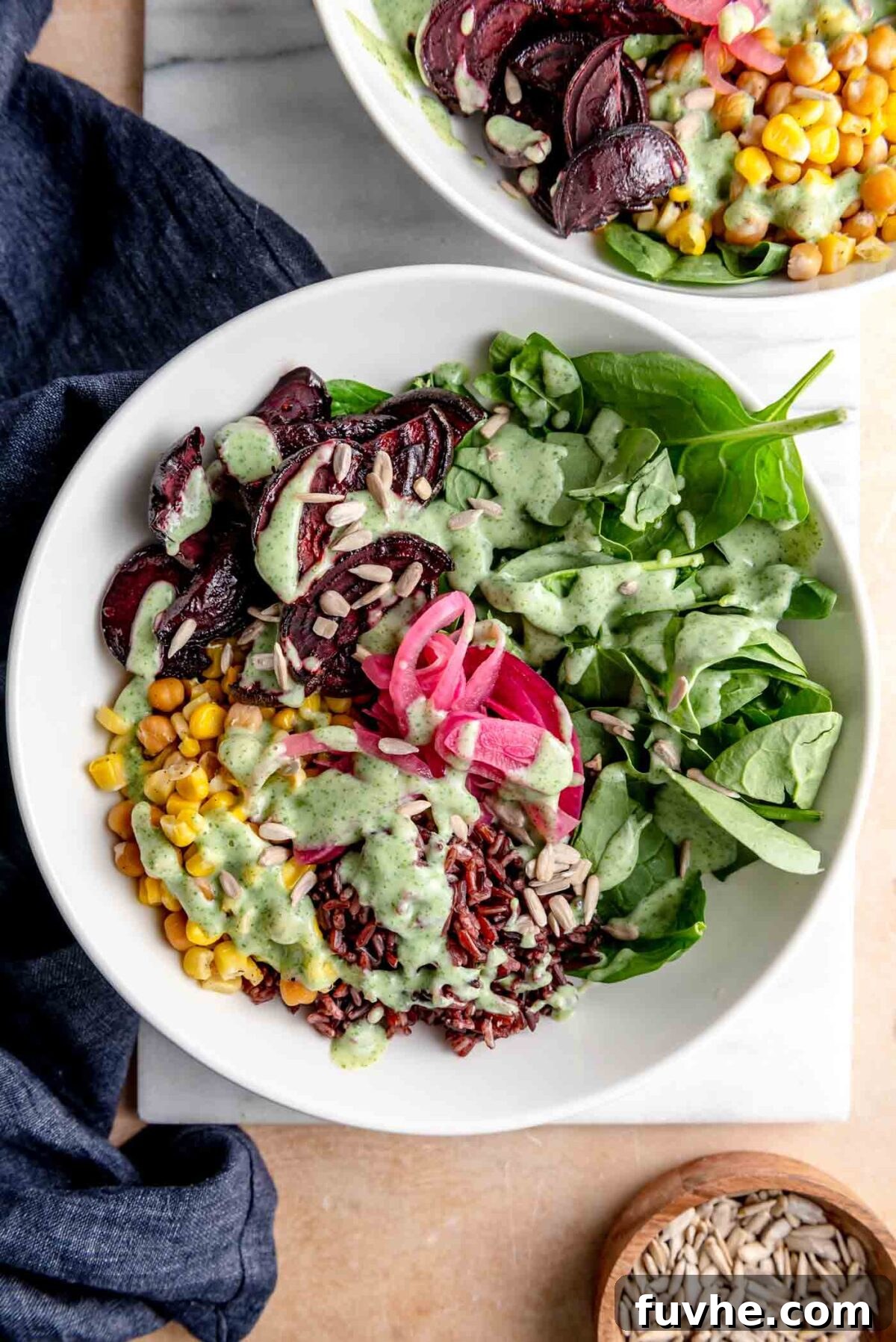 A beautifully assembled wild rice bowl, showcasing a harmonious blend of cooked wild rice, fresh spinach, roasted beets, golden corn, chickpeas, and a generous drizzle of the creamy herb lemon yogurt sauce, ready to be enjoyed.