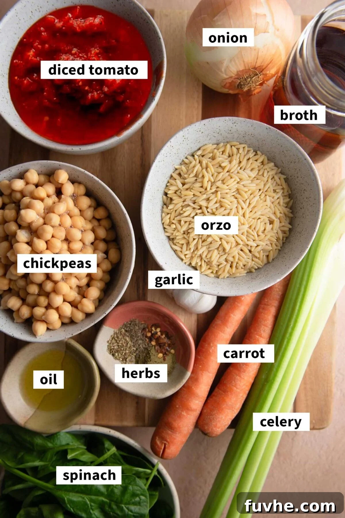 Vibrant Tomato Orzo Soup 3 All the fresh and pantry staple ingredients beautifully arranged for making a vegan tomato orzo soup, including spinach, chickpeas, and carrots, each clearly labelled.