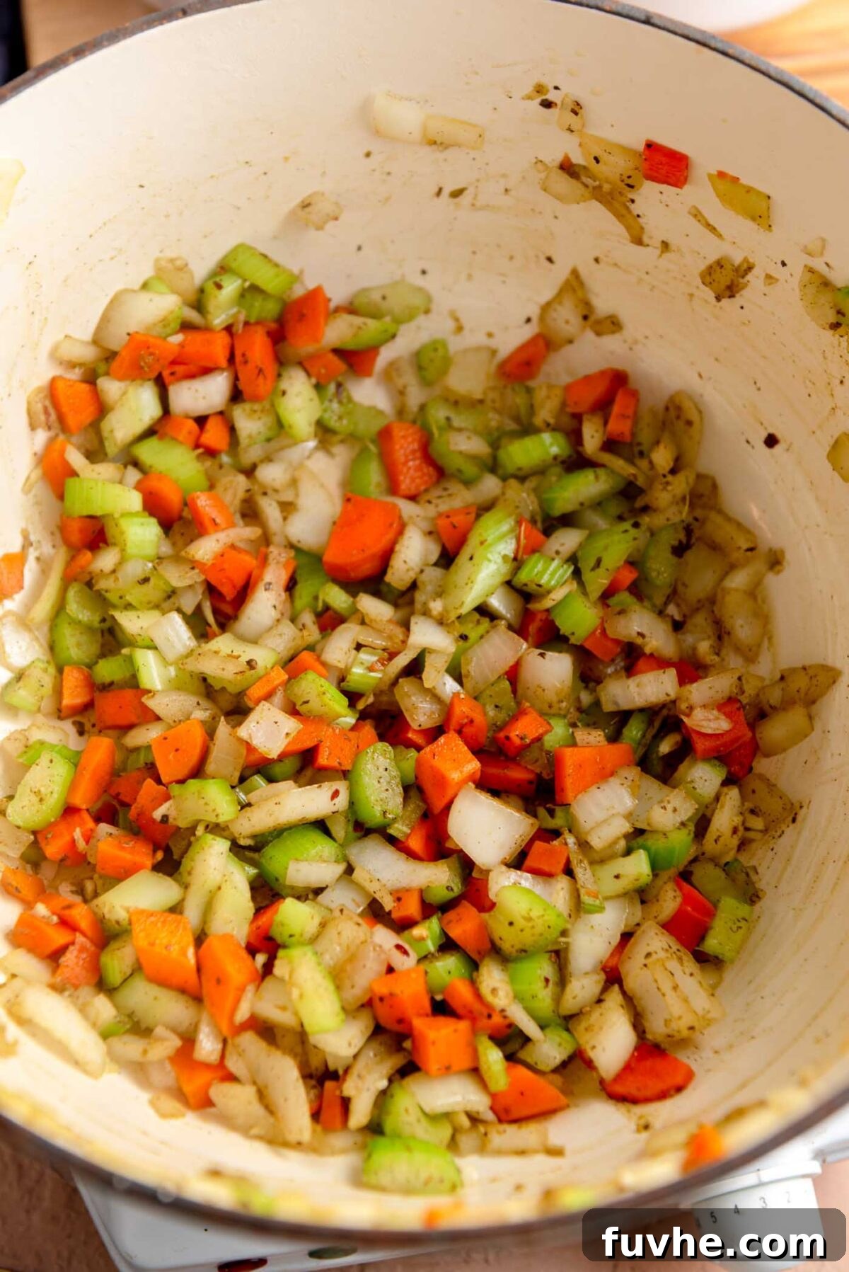 Vibrant Tomato Orzo Soup 5 The aromatic blend of carrots, celery, garlic, onion, and dried herbs sizzling gently in a soup pot, preparing for the next liquid additions.