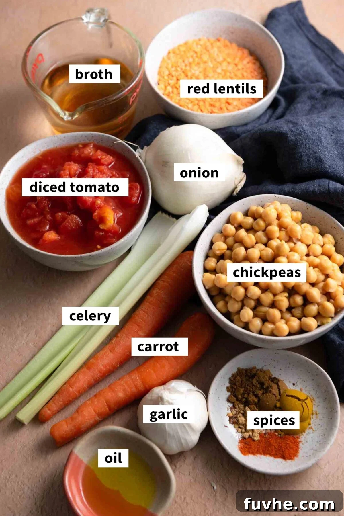 All ingredients for making a vegetarian red lentil chickpea soup with carrot, celery, garlic, onion and tomato.