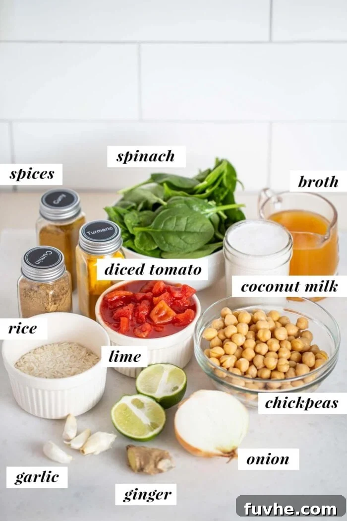 Labelled ingredients in various small bowls for making a tomato rice and chickpea stew.