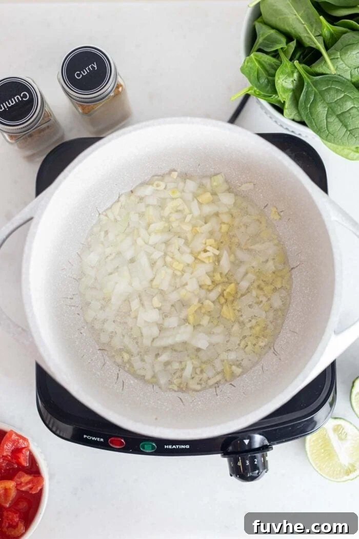 Onions, garlic and ginger cooking in a pot.