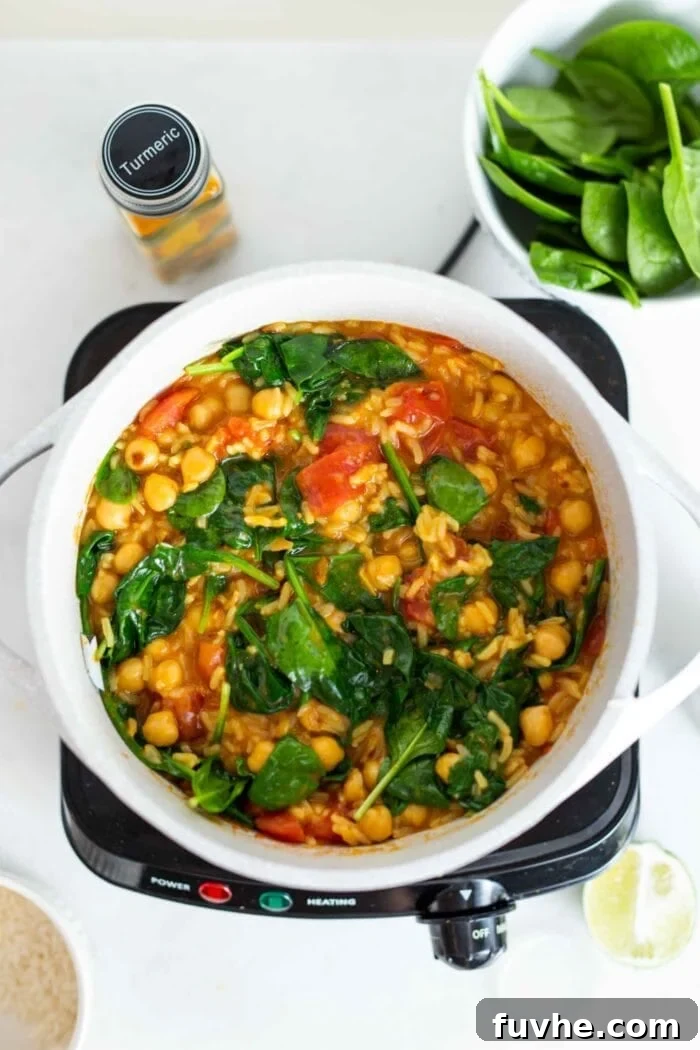 A pot of chickpea and rice stew with spinach.
