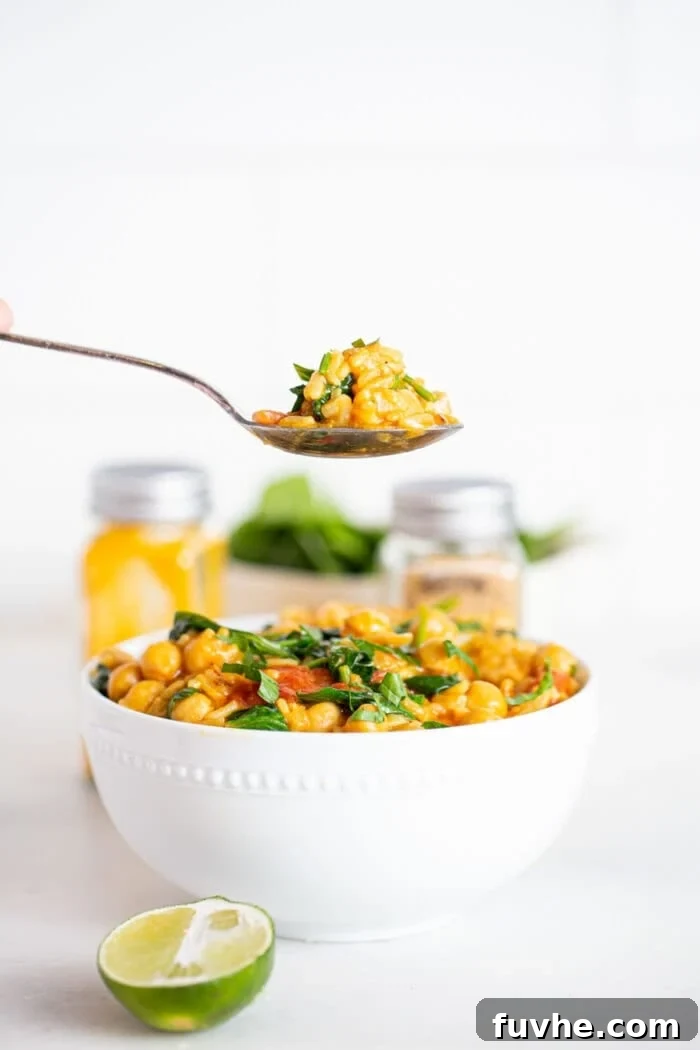 Taking a spoonful of rice, chickpea and spinach stew.