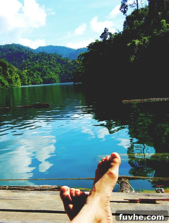 Serene view of floating huts against the majestic limestone karsts of Chiew Lan Lake
