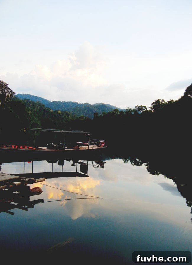 Longtail boats resting on the serene waters of Chiew Lan Lake at dusk