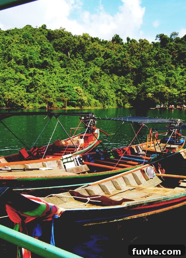 Vibrant longtail boat in the stunning waters of Chiew Lan Lake, Thailand