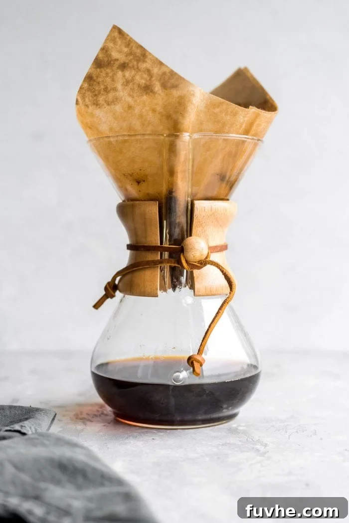 Chemex coffee maker with brewed coffee in it.