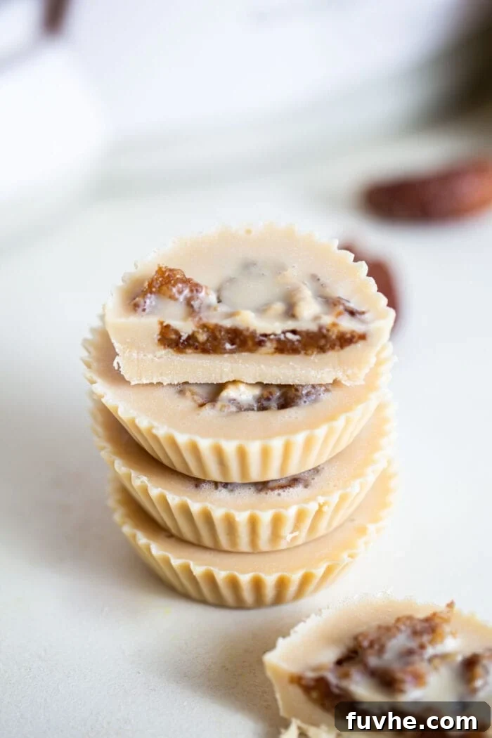 Salted Caramel Tahini Delights 5 A stack of beautifully assembled tahini cups, rich with date caramel and topped with a smooth tahini layer, ready for serving.