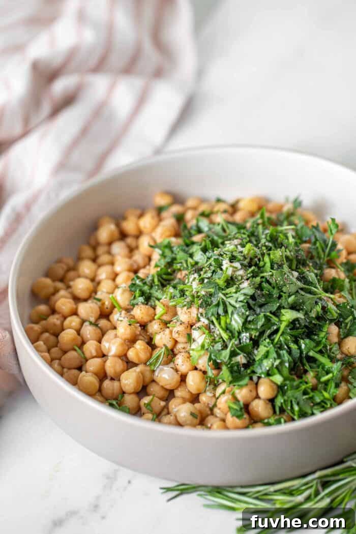 Bright Lemon Garbanzo Salad 3 A bowl filled with freshly chopped rosemary and parsley, ready to be combined with chickpeas for the salad.