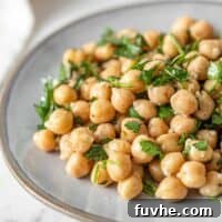 A vibrant and simple chickpea salad featuring fresh herbs and lemon, presented beautifully on a small plate.