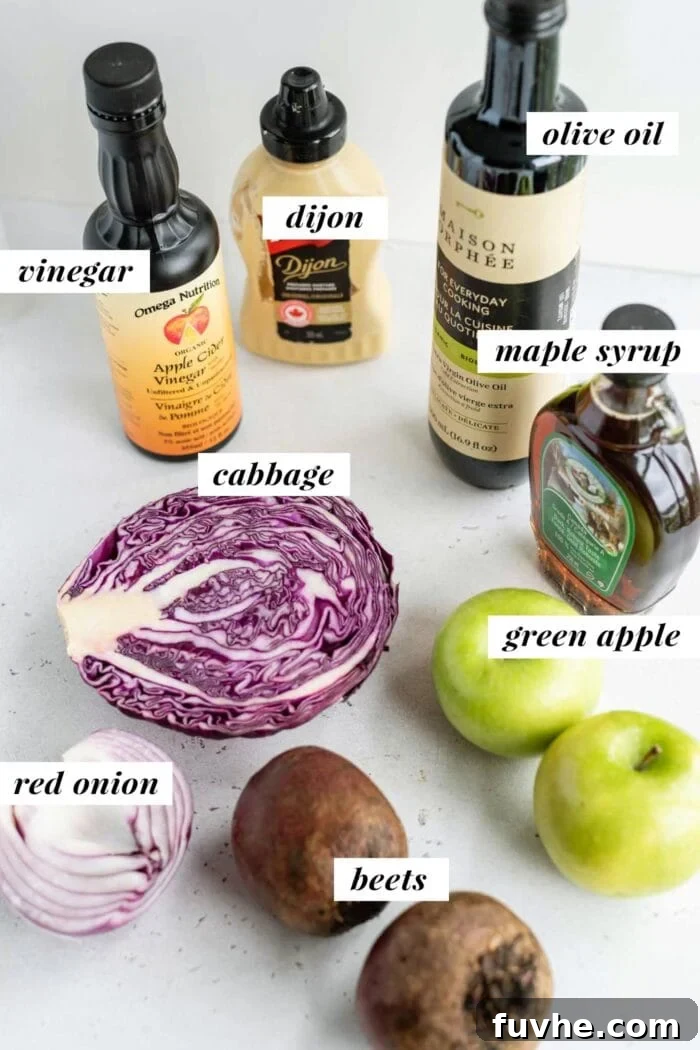 A collection of labeled ingredients including beets, apples, cabbage, onion, and dressing components for a beet, apple, and cabbage salad.