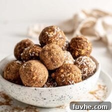 A bowl full of delightful pumpkin energy balls, some exquisitely coated in cinnamon or fresh coconut flakes, showcasing their tempting appeal.