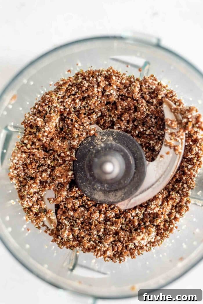 Maca Hemp Vitality Bites 4 Raw energy ball dough being processed in a food processor, showing its sticky texture.