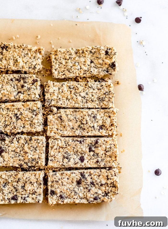 10 sliced oatmeal chocolate chip bars sitting on parchment paper. Chocolate chips scattered around.