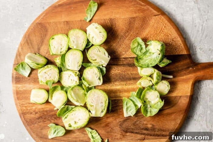 Caramelized Maple Dijon Brussels Sprouts 3 Freshly trimmed and halved Brussels sprouts neatly arranged on a cutting board.