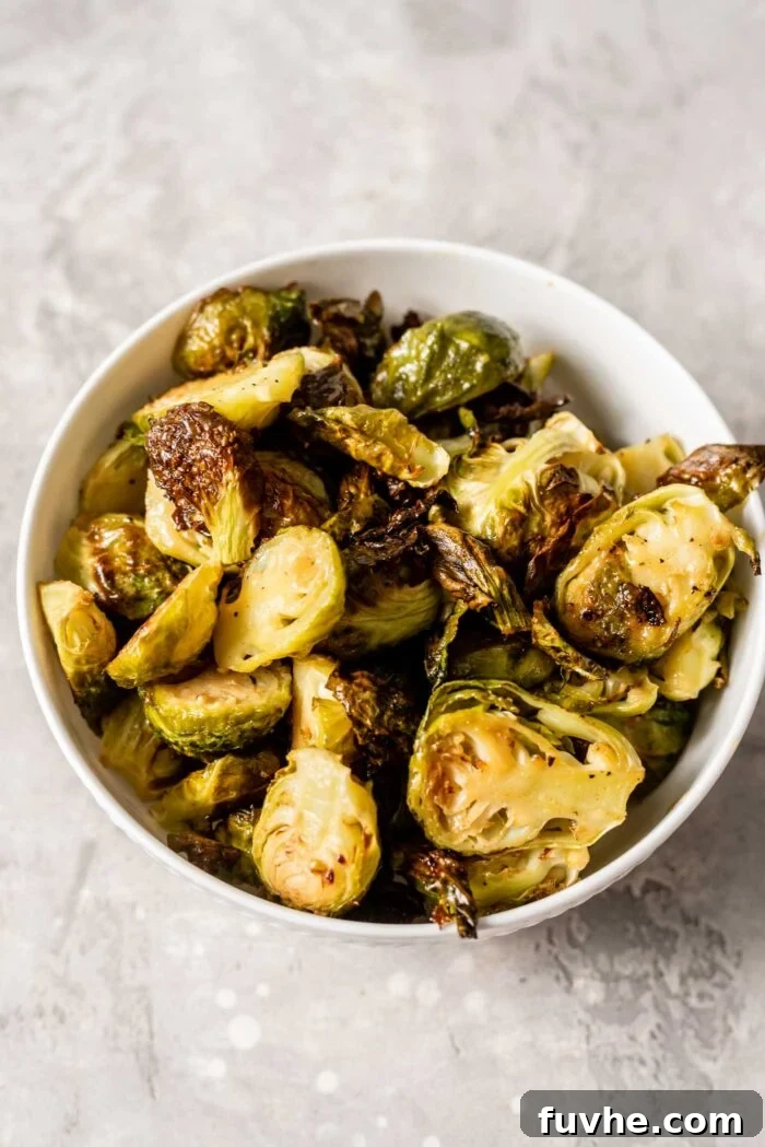 Caramelized Maple Dijon Brussels Sprouts 8 A small white serving bowl filled with finished maple dijon roasted Brussels sprouts.