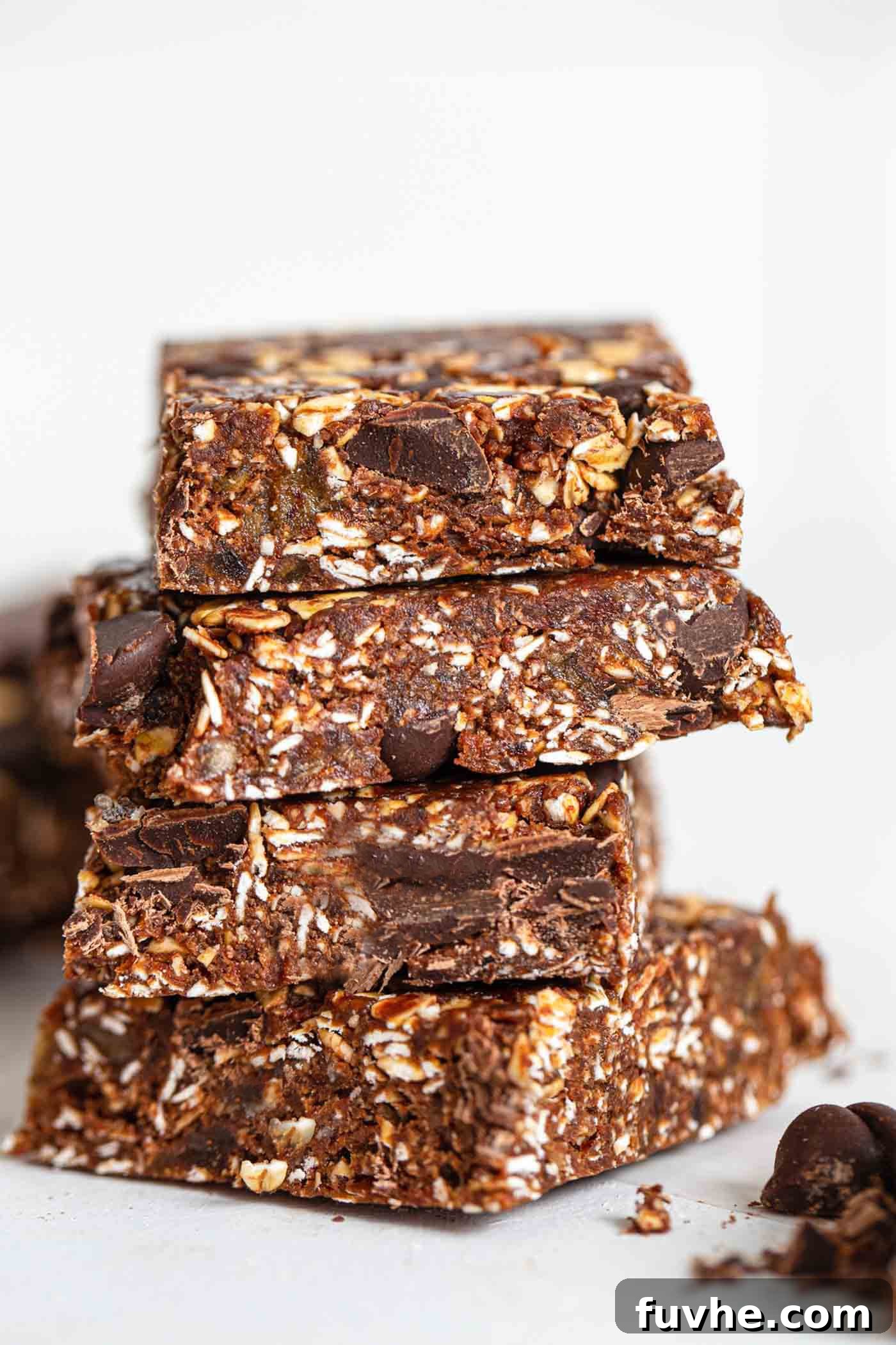 A stack of homemade chocolate peanut butter granola bars with visible chocolate chunks.