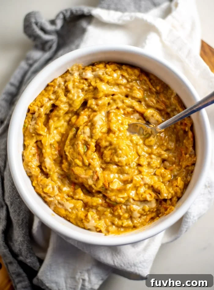 Plant-Based Macro Meal Blueprint 5 A warm bowl of thick pumpkin oatmeal with grated carrot, a comforting and protein-rich vegan breakfast.