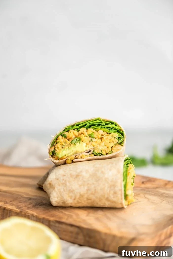 Plant-Based Macro Meal Blueprint 8 A wholesome mashed chickpea and spinach wrap, served on a rustic cutting board, a perfect vegan lunch.