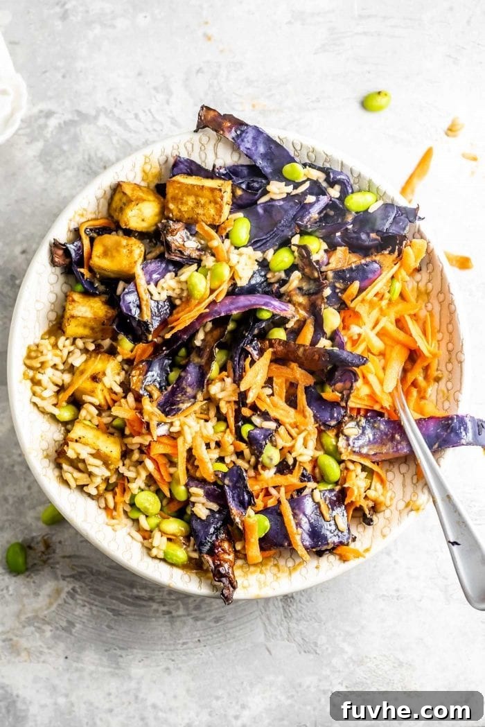 Plant-Based Macro Meal Blueprint 9 A vibrant vegan buddha bowl, rich in colors and nutrients, with tofu, edamame, and grated carrot over rice.
