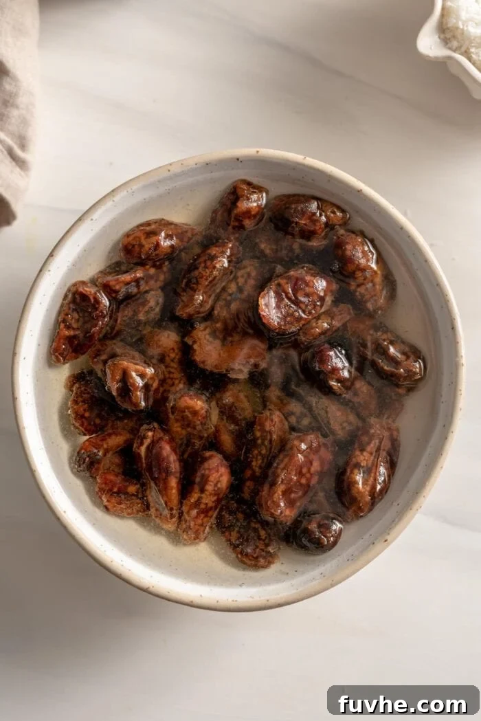 Vegan Coffee Coconut Energy Balls 4 Pitted dates soaking in a bowl of hot water, ready for softening before blending.
