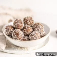 Vegan Coffee Coconut Energy Balls 8 A beautifully composed image of a bowl of protein balls rolled in coconut, positioned elegantly on a plate.