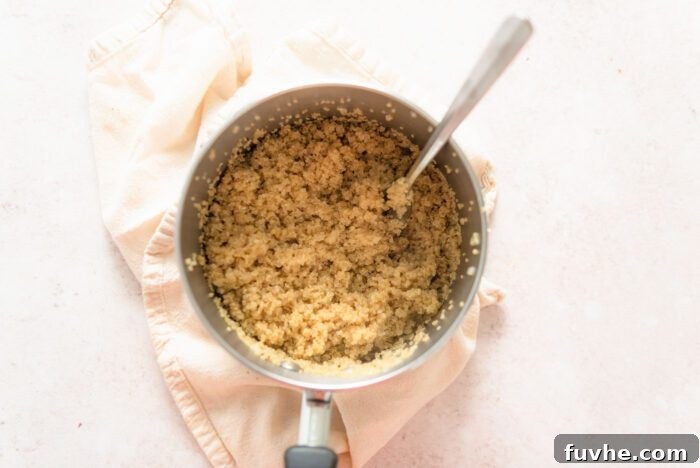 A pot of cooked quinoa with a fork in it.