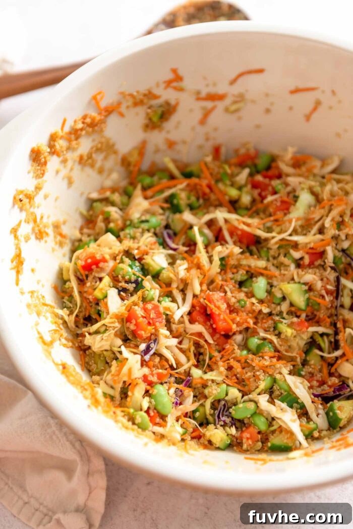 Edamame quinoa salad with carrot, bell pepper and green onion mixed up in a large serving bowl.