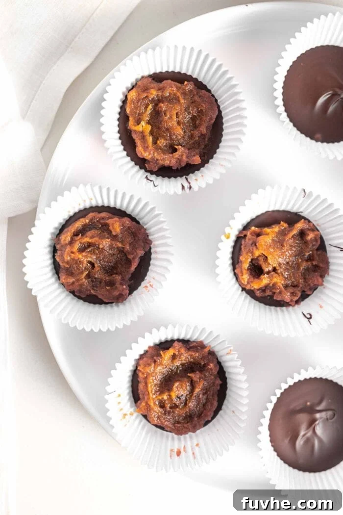Date paste meticulously spread into 6 muffin liners on a plate, over the chocolate base.