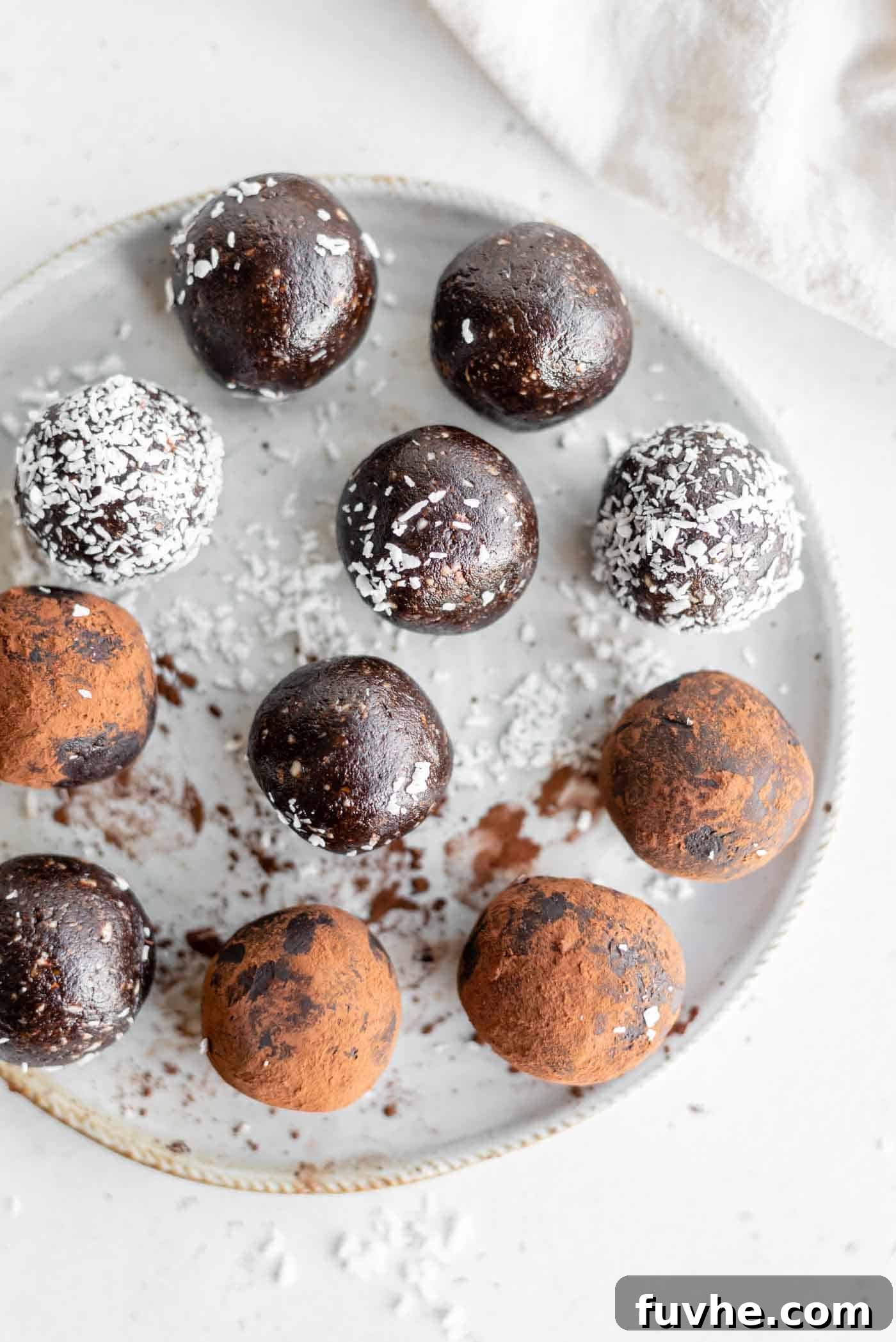 Fudgy No-Bake Brownie Bites 2 A plate of decadent no-bake brownie balls, some rolled in cocoa powder and others in shredded coconut, ready to be enjoyed.