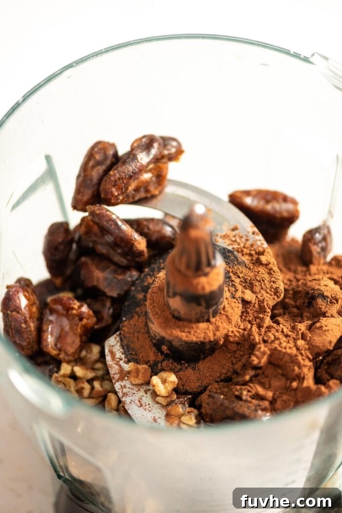 Salty Sweet Vegan Chocolate Truffles 3 Dates, cocoa powder, and walnuts in a food processor, ready to be blended into truffle dough.