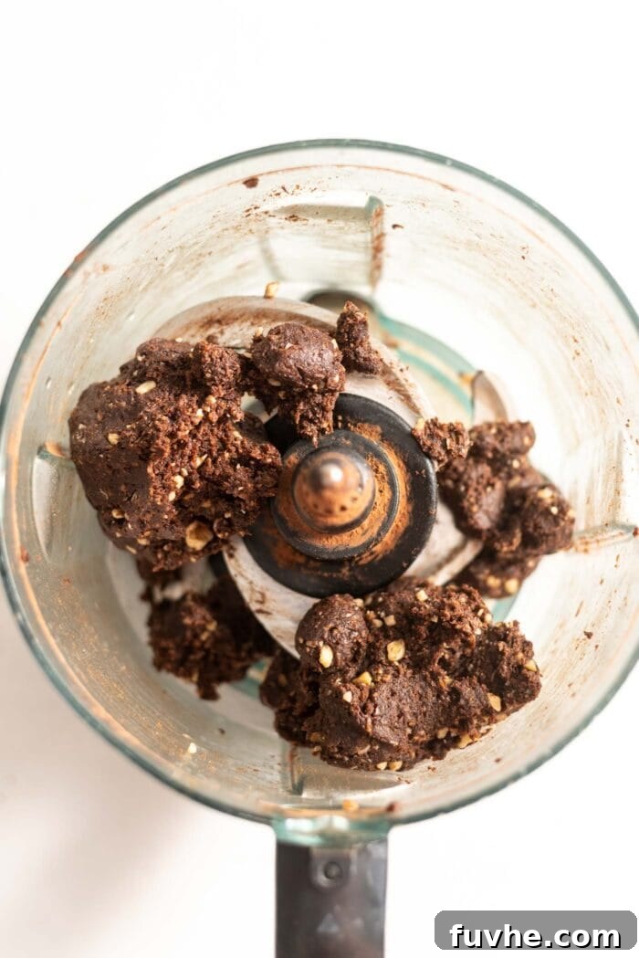 Salty Sweet Vegan Chocolate Truffles 4 Chocolate truffle dough being processed in a food processor, showing its sticky, uniform texture.