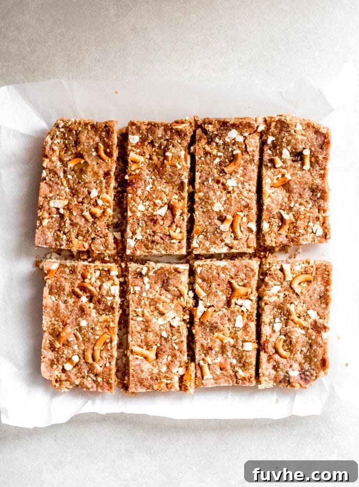 Eight perfectly sliced no-bake pretzel granola bars arranged on a square of parchment paper, showcasing their ready-to-eat appeal.